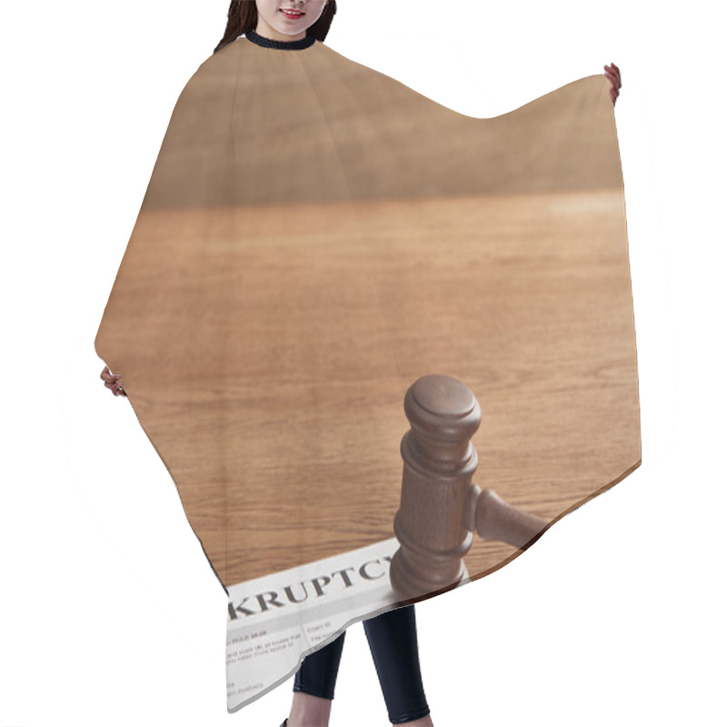 Personality  bankruptcy form under judicial gavel on brown wooden table hair cutting cape