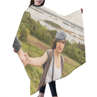 Personality  Fashionable Brunette Woman In Newsboy Cap And Suspenders Holding Hand Of Blurred Boyfriend And Looking At Camera With Scenic Landscape At Background, Fashionable Couple In Countryside Hair Cutting Cape