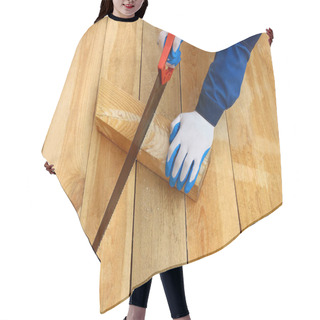 Personality  Male Working Hands In Gloves Sawing A Wooden Board Against The Background Of A Wooden Floor. Construction And Design Of The House. Hair Cutting Cape