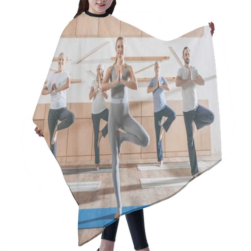 Personality  Group Of Senior People Practicing Yoga With Instructor In Tree Pose On Mats In Studio Hair Cutting Cape