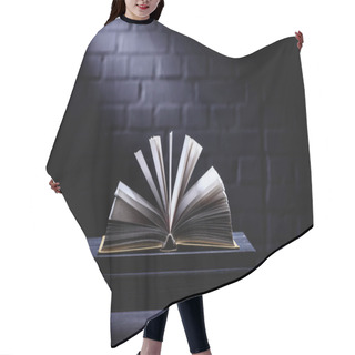 Personality  Open Book On Dark Tabletop With Light On Pages Hair Cutting Cape