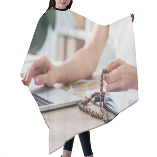 Personality  Cropped View Of Businesswoman Using Laptop And Holding Rosary Beads At Workplace Hair Cutting Cape