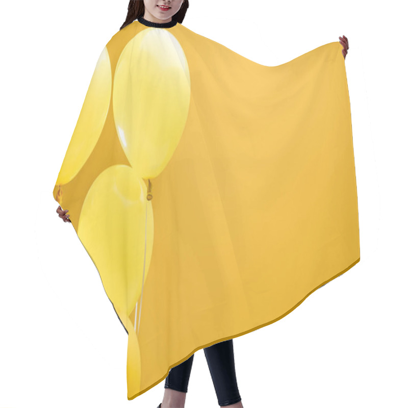 Personality  festive minimalistic decorative balloons on yellow background with copy space hair cutting cape