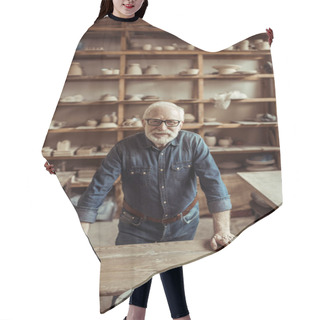 Personality  Front View Of Senior Potter Standing And Leaning On Table Against Shelves With Pottery Goods At Workshop Hair Cutting Cape