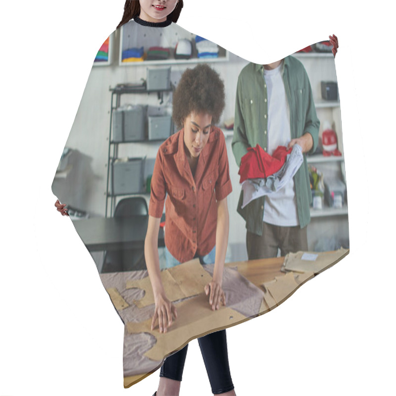 Personality  Young African American Craftswoman Putting Sewing Patterns On Fabric And Working Near Smiling Redhead Colleague In Print Studio, Ambitious Young Entrepreneurs Concept  Hair Cutting Cape