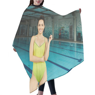 Personality  A Vibrant Brunette Woman In A Yellow Swimsuit Posing Elegantly By An Indoor Swimming Pool. Hair Cutting Cape
