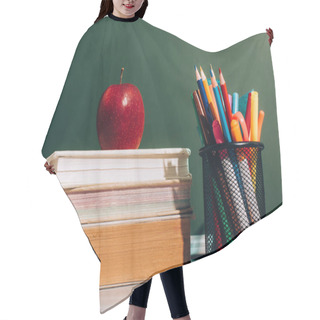 Personality  Ripe Apple On Books And Pen Holder With Color Pencils And Felt Pens On Desk Near Green Chalkboard Hair Cutting Cape