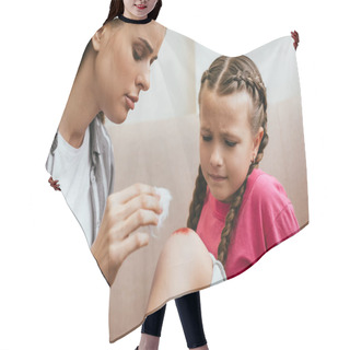 Personality  Mother Holding Antiseptic Cotton Near Wound On Knee Of Sad Daughter Hair Cutting Cape