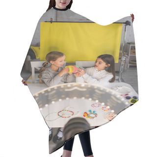 Personality  Preteen Bloggers Showing Spiral Toy Near Blurred Digital Camera In Circle Light On Yellow Background At Home Hair Cutting Cape