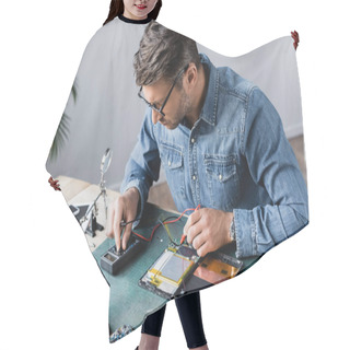 Personality  Repairman Regulating Multimeter While Holding Sensors Near Disassembled Part Of Broken Digital Tablet At Workplace Hair Cutting Cape