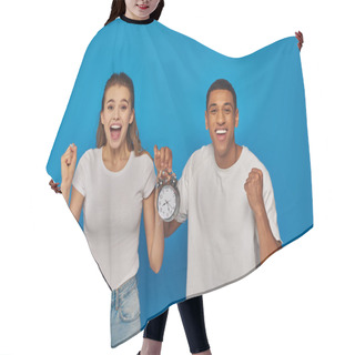Personality  Excited Interracial Couple With Open Mouth Holding Alarm Clock On Blue Background, Face Expression Hair Cutting Cape