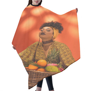 Personality  Confident Young African American Woman Holding Basket With Exotic Fruits On Orange Hair Cutting Cape