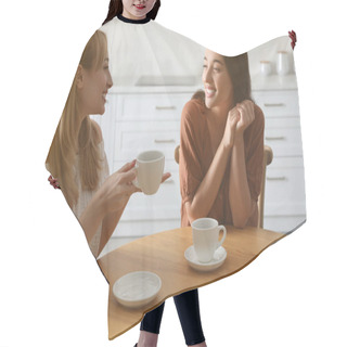 Personality  Young Women Talking While Drinking Tea At Table In Kitchen Hair Cutting Cape
