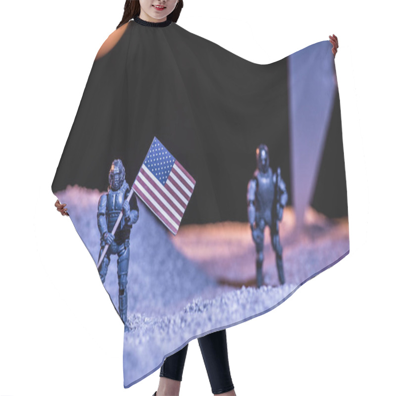 Personality  Selective Focus Of Toy Astronauts Holding American Flag In Space  Hair Cutting Cape