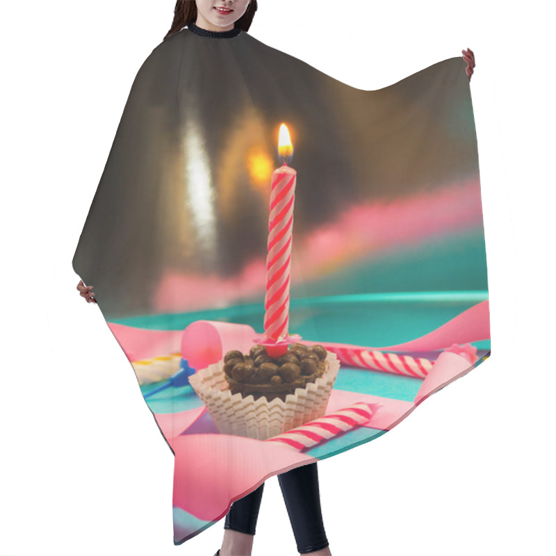 Personality  candle on birthday burning in the background other candles, pink ribbons, festive atmosphere hair cutting cape