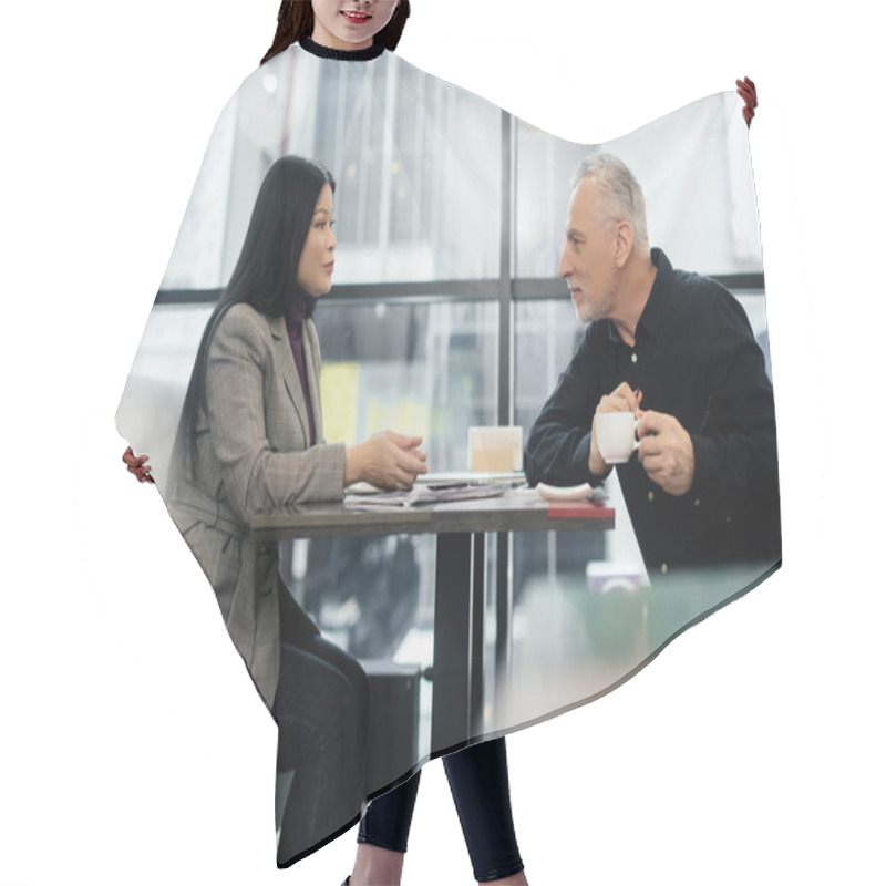 Personality  side view of businessman and asian businesswoman talking in cafe  hair cutting cape