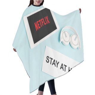 Personality  KYIV, UKRAINE - APRIL 8, 2020: Digital Tablet With Netflix App Near Headphones And Paper With Stay At Home Lettering On Blue  Hair Cutting Cape