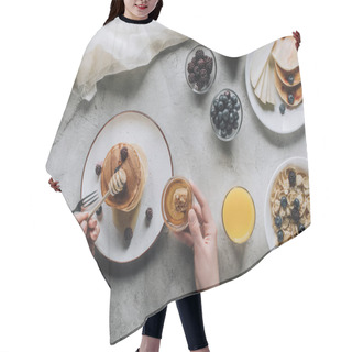 Personality  Cropped Shot Of Person Eating Delicious Homemade Pancakes With Honey And Fruits On Grey Hair Cutting Cape