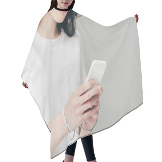 Personality  Cropped View Of Young Woman In White T-shirt And Usb Cable Around Hands Using Smartphone Isolated On Grey Hair Cutting Cape