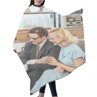 Personality  Happy Fifties Style Couple Looking Away While Sitting On Sofa And Holding Hands Hair Cutting Cape