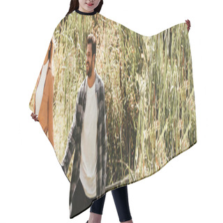 Personality  Panoramic Shot Of Cheerful Young Couple Holding Hands While Walking In Thicket Of Sedge Hair Cutting Cape
