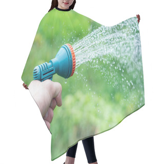 Personality  Gardener's Hand Holds A Hose With A Sprayer And Watered The Plants In The Garden. Hair Cutting Cape
