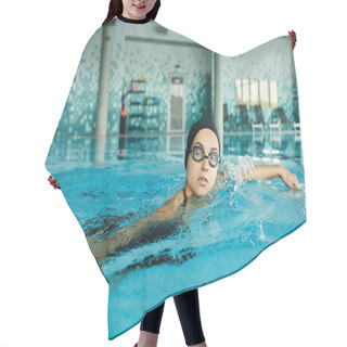 Personality  A Young Woman In A Swimsuit And Goggles Gracefully Swims In An Indoor Pool, Showcasing Her Swimming Skills. Hair Cutting Cape