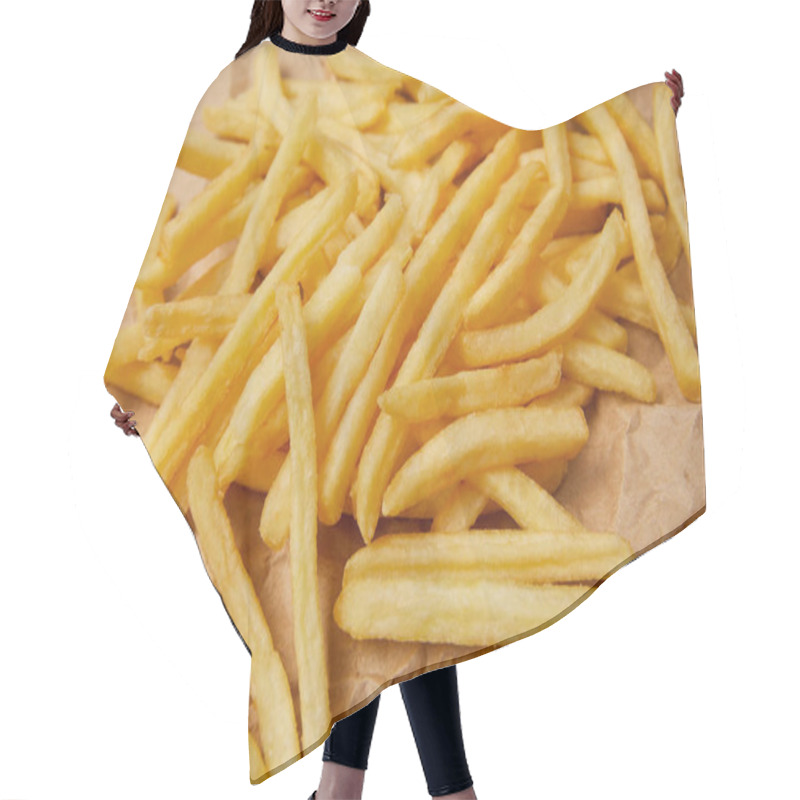 Personality  close-up shot of delicious french fries spilled over crumpled paper hair cutting cape