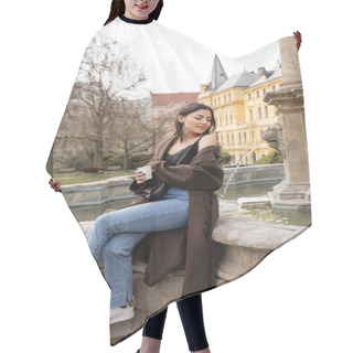 Personality  Young Woman In Coat And Jeans Holding Paper Cup Near Fountain In Charles Square In Prague  Hair Cutting Cape