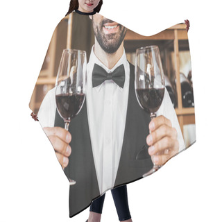 Personality  Cropped Shot Of Smiling Young Sommelier Holding Two Glasses Of Red Wine At Wine Store Hair Cutting Cape