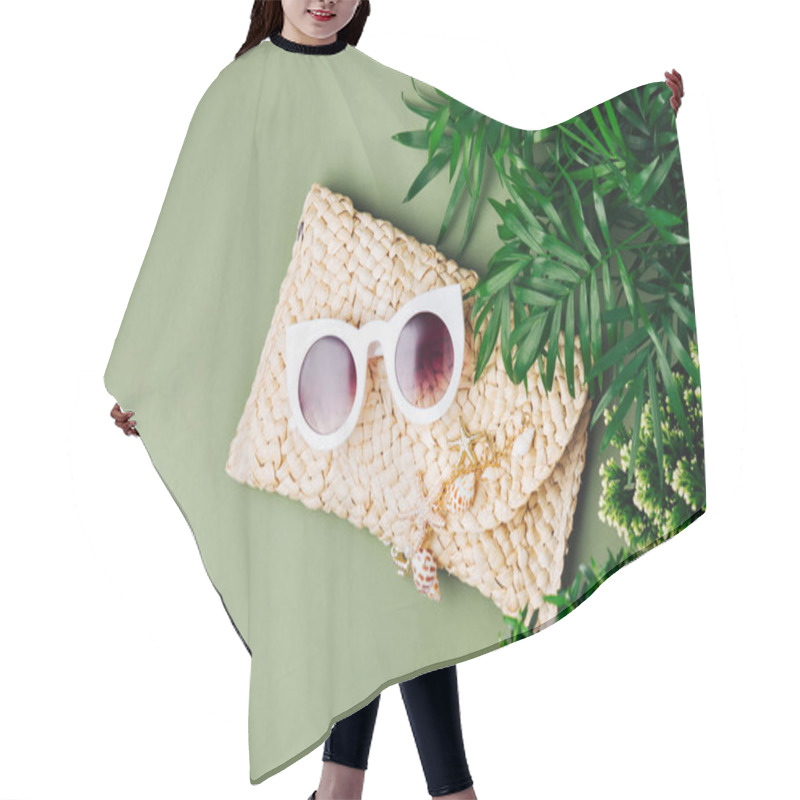 Personality  Tropical leaves and Beach bag with sunglasses  on  green  background. Top view, flat lay. hair cutting cape