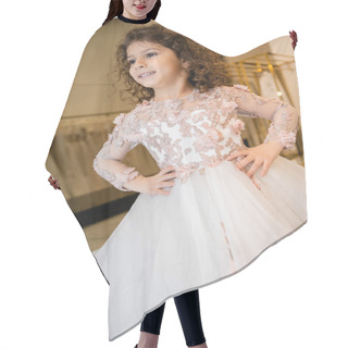 Personality  Joyous Middle Eastern Kid In Floral Dress With Tulle Skirt Standing With Hands On Hips And Looking Away In Bridal Boutique, Preparation For Wedding, Blurred Background, Low Angle, Flower Girl Hair Cutting Cape