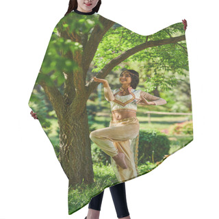 Personality  Happy Indian Woman In Elegant Authentic Attire Dancing Under Tree On Green Lawn, Summer Sunny Park Hair Cutting Cape