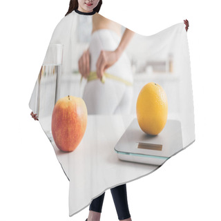 Personality  Selective Focus Of Fruits, Glass Of Water And Scales On Table Near Slim Girl Measuring Hips In Kitchen, Calorie Counting Diet Hair Cutting Cape