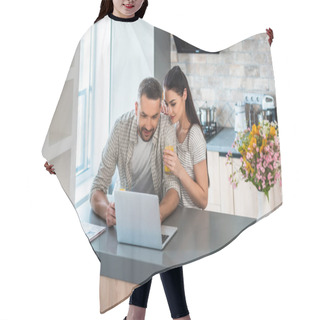 Personality  Portrait Of Married Couple Using Laptop Together At Counter In Kitchen Hair Cutting Cape