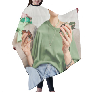 Personality  Partial View Of Casual Style And Tattooed Woman Holding Trendy Sunglasses Near Clothing On Couch, Decluttering, Sorting, Sustainable Living And Mindful Consumerism Concept Hair Cutting Cape