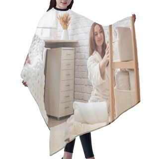 Personality  Woman In Robe Is Sitting Near Wooden Shelving, Organizing Closet By Sorting And Folding Bath Towels And Placing Into White Wicker Basket While Touching White Colored Don Sphynx Cat. Spring Cleaning. Hair Cutting Cape