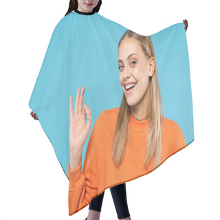 Personality  Cheerful Woman In Orange Sweatshirt Showing Ok Gesture Isolated On Blue  Hair Cutting Cape