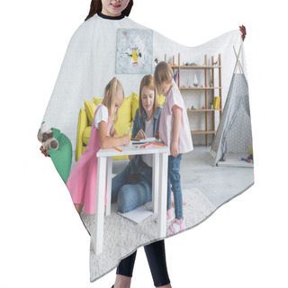 Personality  Smiling Kindergarten Teacher Talking With Toddler Kid With Down Syndrome Near Papers And Color Pencils  Hair Cutting Cape