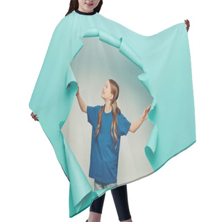 Personality  Cheerful Redhead Girl In T-shirt Smiling And Looking At Blue Torn Paper Hole On White Background, International Child Protection Day Concept  Hair Cutting Cape