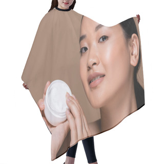 Personality  Young Asian Woman Holding Cosmetic Cream And Looking At Camera Isolated On Brown  Hair Cutting Cape