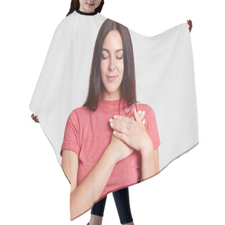 Personality  Calm Brunette Female With Closed Eyes, Keeps Both Palms On Heart, Feels Gratitude, Being Touched By Something, Dressed In Casual Pink T Shirt, Isolated Over White Background. Body Language Concept Hair Cutting Cape
