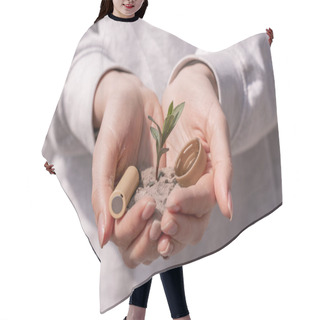 Personality  Cropped View Of Woman Holding Battery, Plastic Cap And Green Plant In Hands Hair Cutting Cape