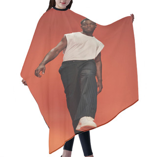 Personality  Full Length Of Charismatic And Fashionable African American Man Posing With Outstretched Leg On Red Hair Cutting Cape