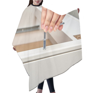 Personality  The Handyman Tightens The Steel Cam Dowel Into The Part Of The Table Made Of Particle Board With A Hex Key, Flat Pack Furniture Assembly. Hair Cutting Cape