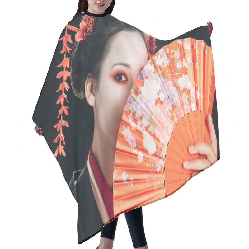 Personality  beautiful geisha with red flowers in hair holding traditional hand fan isolated on black hair cutting cape