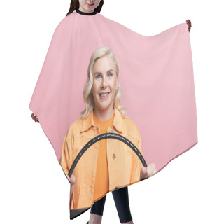 Personality  Happy Blonde Woman Looking At Camera While Holding Steering Wheel Isolated On Pink  Hair Cutting Cape