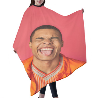 Personality  Funny African American With Closed Eyes Sticking Out Tongue On Red Background, Orange Shirt, Stylish Hair Cutting Cape