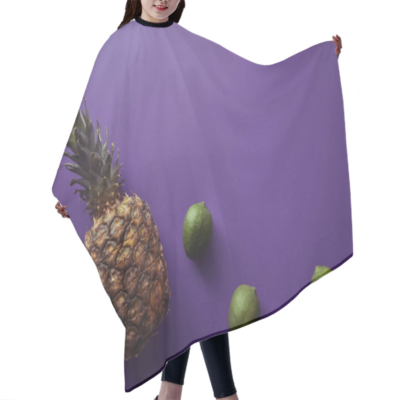 Personality  top view of pineapple and limes on violet surface hair cutting cape