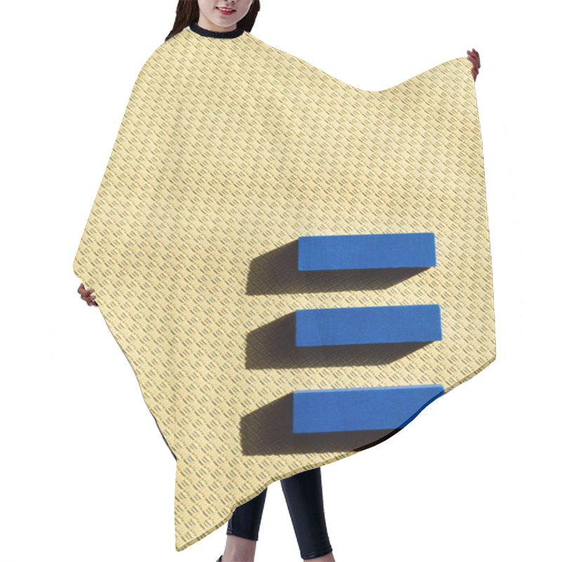 Personality  top view of three blue blocks on beige textured background hair cutting cape